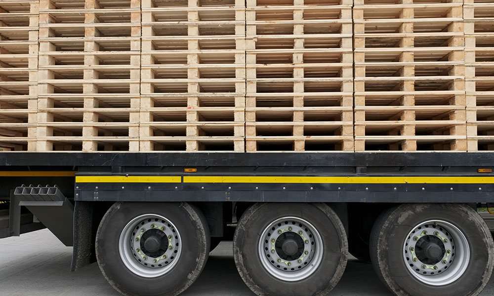 Trailer loaded with stacked wood pallets for commercial transport