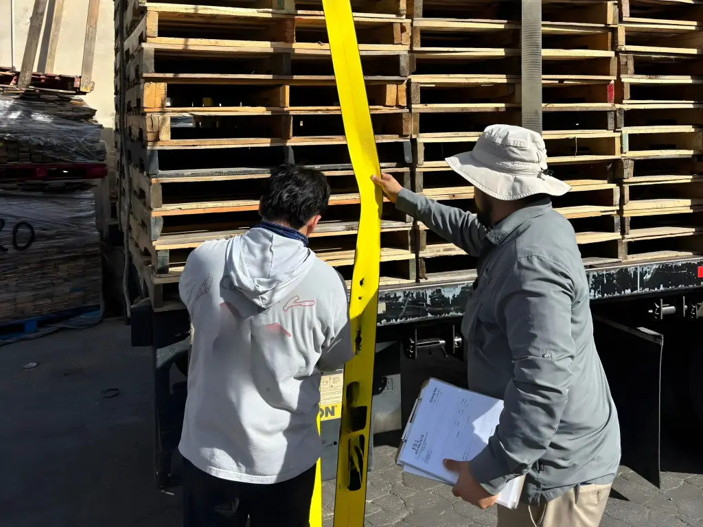 Team securing stacked wood pallets for commercial shipment at SFV Pallet yard